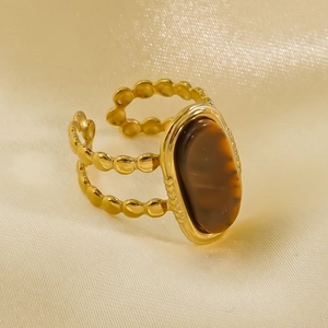 Macro detail of vintage 14K gold plated ring with oval tiger eye stone and beaded band