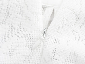 Detailed macro view of white lace fabric featuring a premium hidden invisible zipper closure