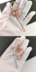 Detail of rose gold DIY beaded keychain hardware held in hand showing high metal luster