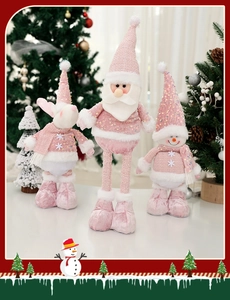 Close-up of pink and white plush Christmas ornaments including snowman and reindeer figurines