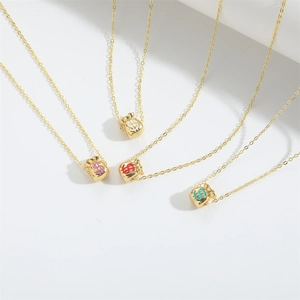 Close-up of golden money bag pendants with colorful dollar signs on delicate chains