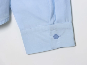 Close-up of light blue long-sleeved shirt cuff with a matching round button detail