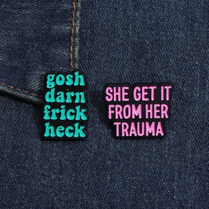 Detailed close-up of funny enamel slogan badges pinned on blue denim jacket texture