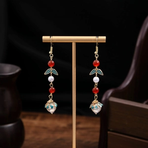 Close-up of vintage red beads and pearl earrings with blue enamel auspicious cloud charms
