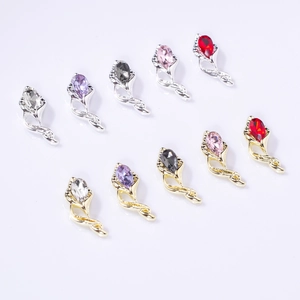 Macro shot of horseshoe flower nail art charms with colorful teardrop gems and alloy base