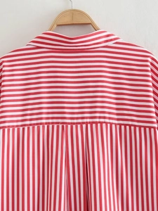 Detail of red and white striped poplin shirt collar showing stitching on wooden hanger