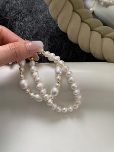 Close-up of baroque freshwater pearls with tiny gold beads on a luxury bracelet