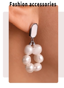 Close-up of a model wearing freshwater pearl hoop earrings with silver metal details
