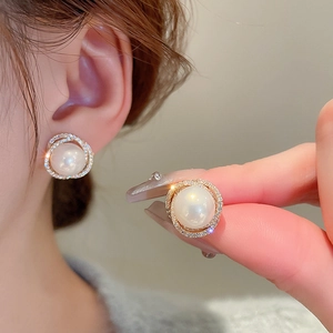 Elegant gold spiral stud earrings with white pearl and sparkling zircon stones