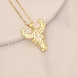 Detail of gold bull head pendant with white zircon symbol on dainty O-chain necklace