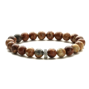 Macro detail of natural tiger eye beads bracelet with textured silver metal spacer charm