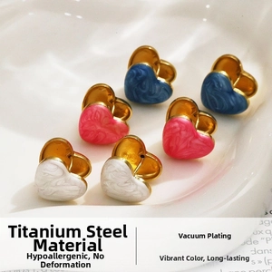 Vue macro de boucles d'oreilles cœur en émail marbré et acier titane durable