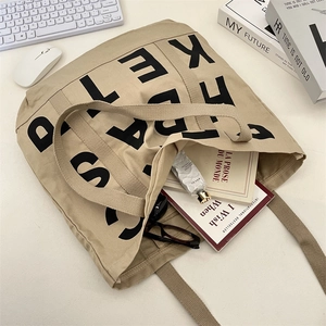 Detail view of large khaki canvas tote bag showing interior storage capacity for daily essentials