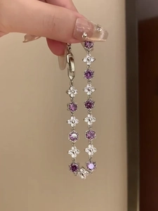 Macro shot of silver zircon bracelet with purple flowers and hexagonal clasp details