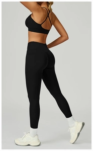Détail du legging de yoga noir à taille haute avec poches latérales et ceinture croisée