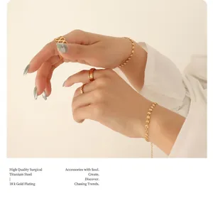 Detail of 18K gold plated titanium steel bracelet and rings set shown on model skin