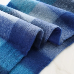 Close-up of thick brushed cashmere-like scarf with blue gradient plaid and fuzzy texture