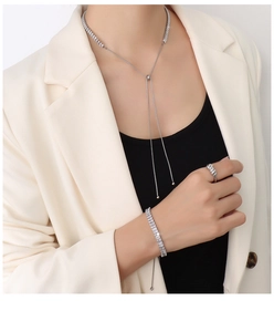 Dettaglio del set di gioielli in argento e zirconi con pietre baguette su modella