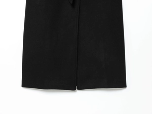 Detailed close-up of the hem split and texture on this black wool blend coat for women