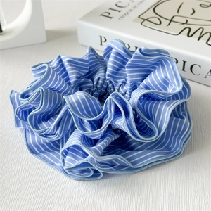 Nahaufnahme des blau-weiß gestreiften Stoff-Scrunchies mit weichen Falten-Details