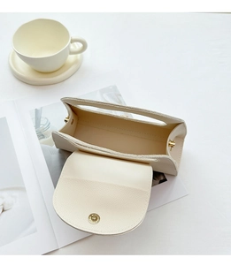 Top view of cream leather handbag with lychee texture showing magnetic closure interior