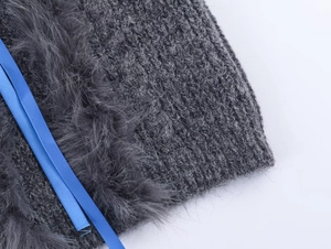 Detailaufnahme des dunkelgrauen Strickpullis mit Kunstpelz und blauen Seidenbändern