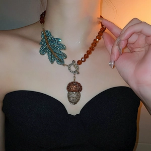 Gros plan du collier vintage à pignon avec feuille de cristal et perles d'ambre