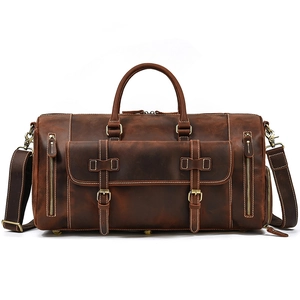 Detail view of vintage brown leather travel bag with metal buckles and functional pockets