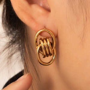 Close-up of interlocking gold-plated 18K loops earrings on model for a layered look