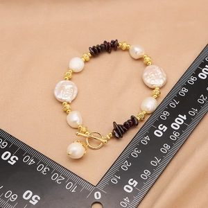 Baroque pearl and garnet beaded bracelet with OT clasp on beige silk background