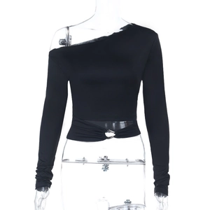 Détail du crop top noir à épaule dénudée avec boucle métallique et empiècements en résille
