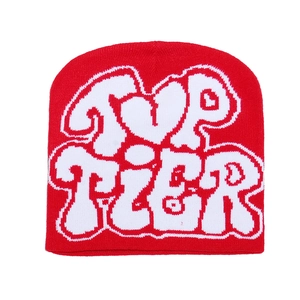 Détail montrant la texture en maille épaisse et le jacquard blanc Top Tier sur un bonnet rouge