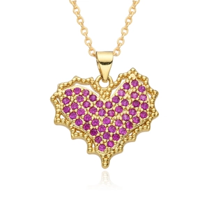 Close-up of heart-shaped gold necklace with pavé-set rose red gemstones and beaded edging
