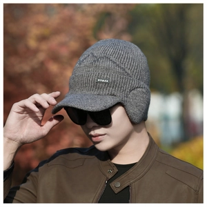 Close-up of a grey thermal knit beanie with ear flaps and short brim for winter