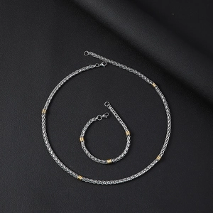 Dettaglio del set collana e bracciale a catena a spina di pesce in oro e argento