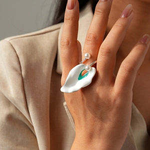 Irregular petal-shaped ring with green enamel, white pearls, and a silver metal band