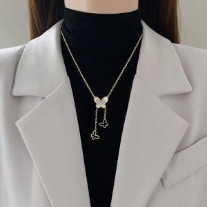Titanium steel butterfly necklace with mother of pearl pendant worn on black turtleneck