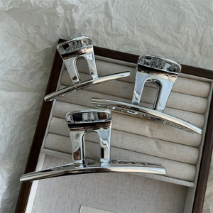 Three large silver alloy hair claws displayed in a premium wooden jewelry organizer tray