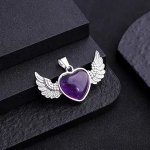 Natural amethyst heart pendant with silver angel wings on a dark textured surface