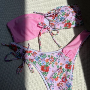Détail à plat d'un bikini à fleurs avec haut bandeau à nouer et bas à échancrure haute