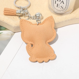 Close-up of khaki suede kitten keychain with tassel and silver bell detail