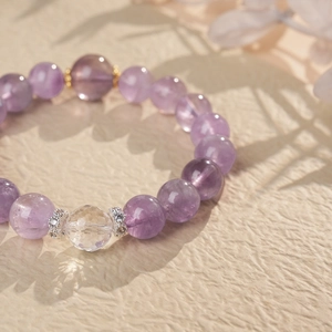 Macro shot of purple amethyst beaded bracelet featuring a faceted crystal and silver spacers