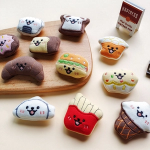 Plush cartoon food toys featuring hamburger, fries, and croissant on a beige background