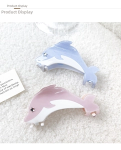 Detail of dolphin hair claws in pink and blue with star-shaped crystal accents