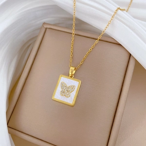 Elegant gold butterfly shell pendant necklace with sparkling crystals on silk background
