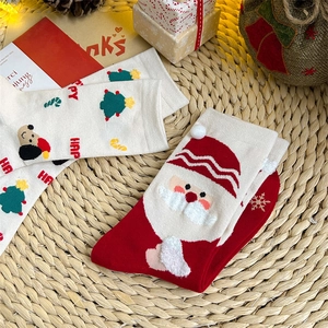 Detail of Christmas cotton socks with festive patterns like Santa and trees in a gift box