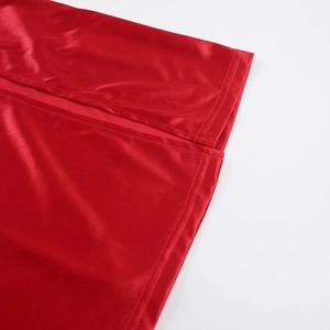 Close-up detail of smooth red satin fabric texture on a slim fit evening dress