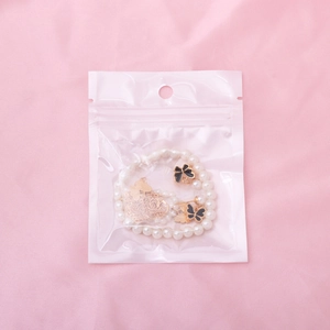Détail d'un ensemble de bijoux papillon avec perles et boucles d'oreilles dorées sur tissu