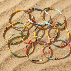 Bohemian multi-layer colorful Tila bead stretch bracelets on a summer sandy beach background