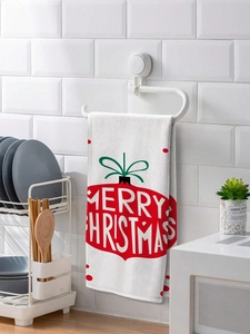 Christmas dish towel with red Merry Christmas print hanging on a kitchen rack decor